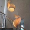 Wood Shell Shape Pendant Light with Warm Glow Beside Staircase Railing